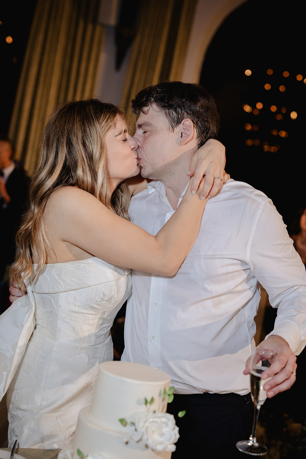 Newlyweds Kiss after Cutting Cake at Wave Hill Garden Wedding